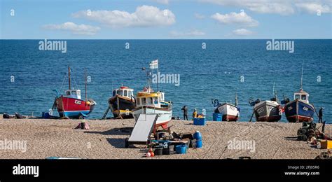 Group Of Six Small Fishing Boats Beached On The Shingle At Beer Beach