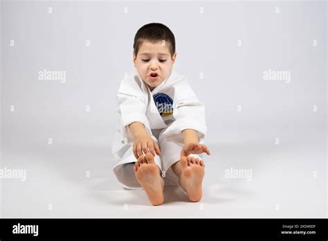 A Little Boy In A Kimono Doing Karate Stretches His Hands To The Tips