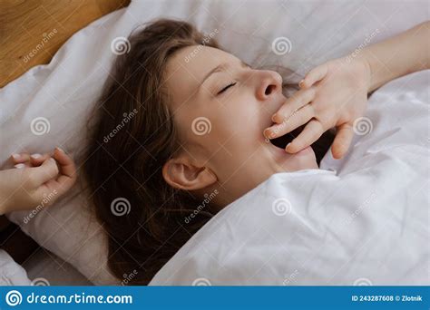 A Young Beautiful Girl Woke Up Early In The Morning In Bed And Yawns