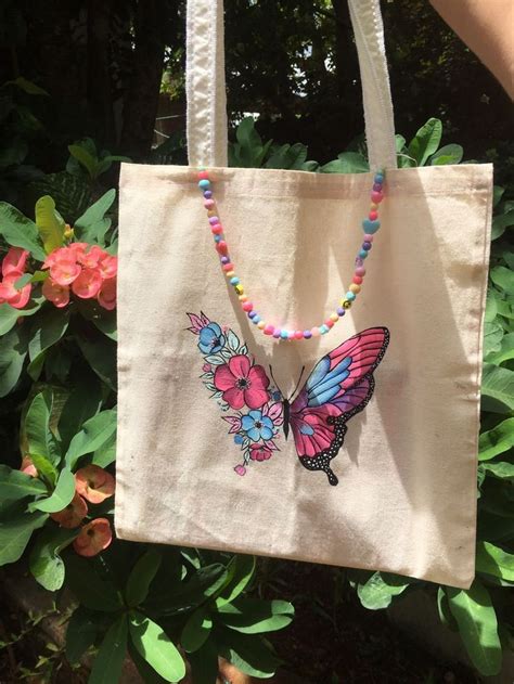 A Hand Holding A Bag With A Butterfly On It