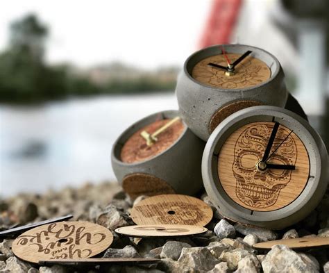 Three Wooden Clocks Sitting On Top Of Some Rocks