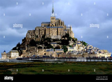 Tourists Walking Towards Mont Saint Michel In Normandy France Stock