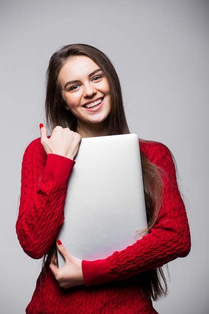 Mujer joven de pie y sosteniendo la computadora portátil niña feliz