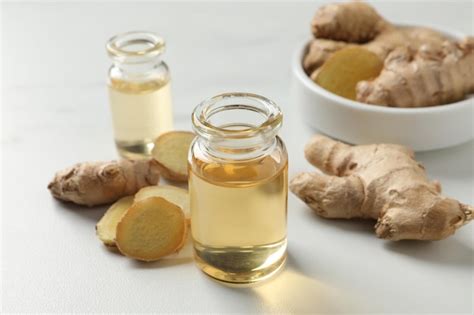 Premium Photo Glass Bottle Of Essential Oil And Ginger Root On White