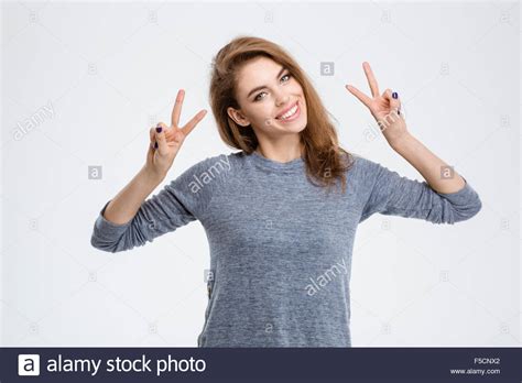 Portrait Of A Smiling Woman Showing Victory Sign Isolated On A White