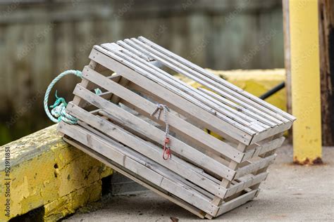 Stockfoto A Single Wooden Lobster Trap On The Side Of An Industrial