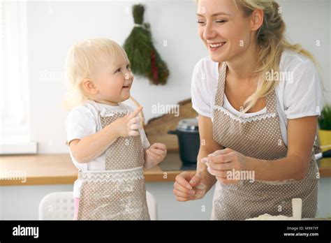 Petite Fille Et Sa Maman Blonde En Rouge Et Rire Tout En Jouant Des Tabliers Le P Trissage La