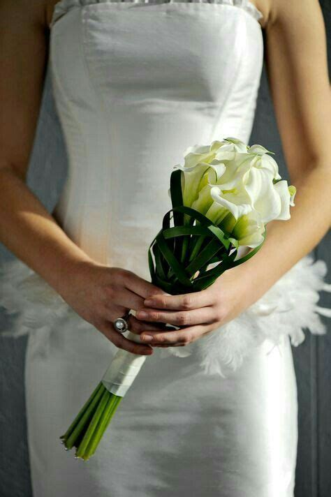 A Bride Holding A Bouquet Of Flowers In Her Hands