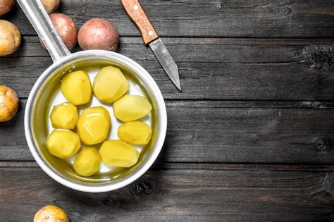 Patatas Peladas En Una Cacerola Con Un Cuchillo Foto Premium