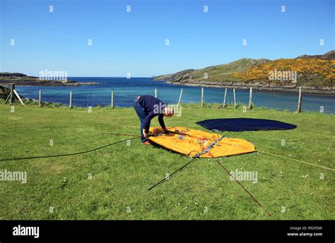 Man erecting a tent at Scourie Campsite in Lairg, Sutherland, Scotland Stock Photo - Alamy