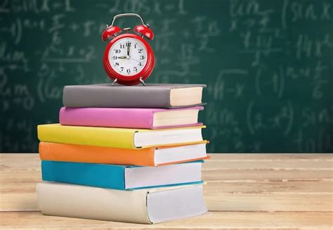 Premium Photo Stack Of Books And Alarm Clock On Wooden Table