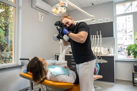 El dentista toma fotografías de los dientes del paciente durante el