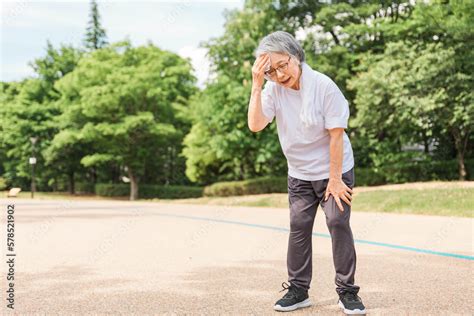 Foto Stock 公園で運動をして体調不良になる高齢者女性（ロコモ・フレイル・サルコペニア・熱中症・日射病・夏バテ） Adobe Stock