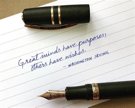 Two Fountain Pens Sitting On Top Of A Piece Of Paper With Writing In