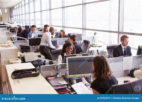 Coworkers At Their Desks In A Busy Open Plan Office Stock Image