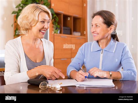 Mature Women Working With Documents And Smiling Focus On Blonde Stock