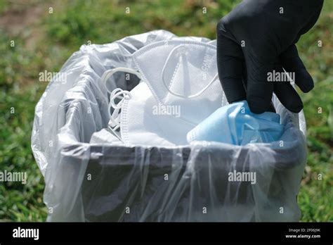 El hombre de la mano mientras la máscara protectora de la basura en el