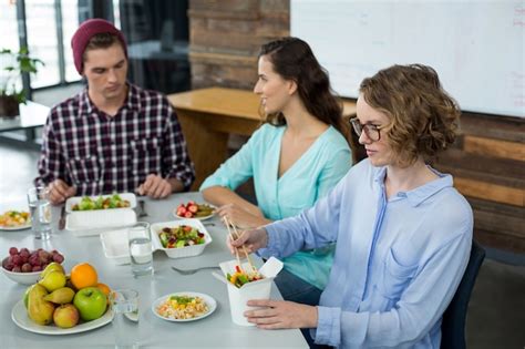 Premium Photo Smiling Business Executives Having Meal In Office