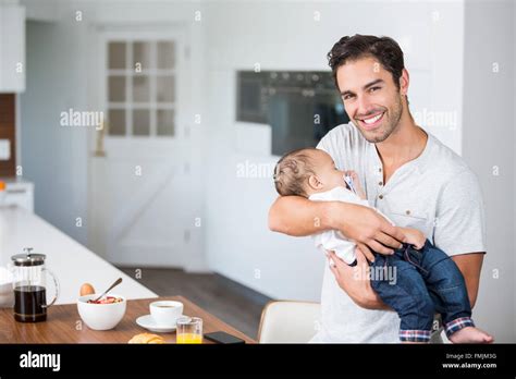 Portrait Of Happy Father Carrying Baby Stock Photo Alamy