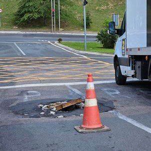 Tampa de bueiro levantada oferece risco em rua próxima ao Burger King