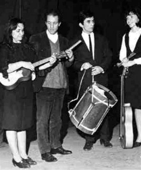 A Group Of People Standing Around Each Other Holding Musical Instruments