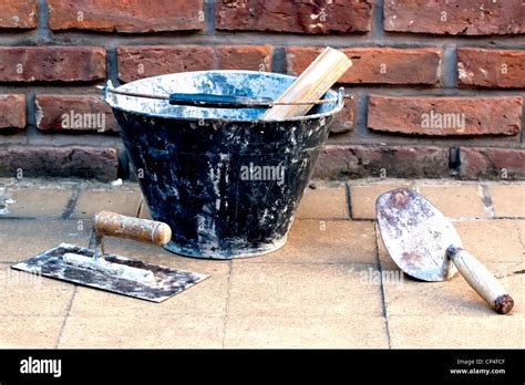 masonry tools near a brick wall Stock Photo - Alamy