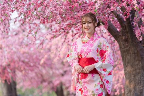 Premium Photo Woman In Yukata Kimono Dress Looking Sakura Flower Or