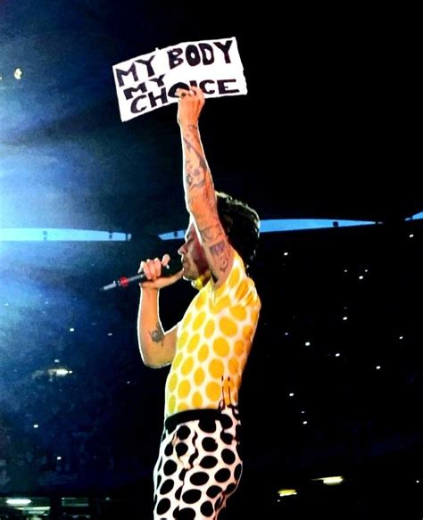 a man holding up a sign while standing on top of a stage