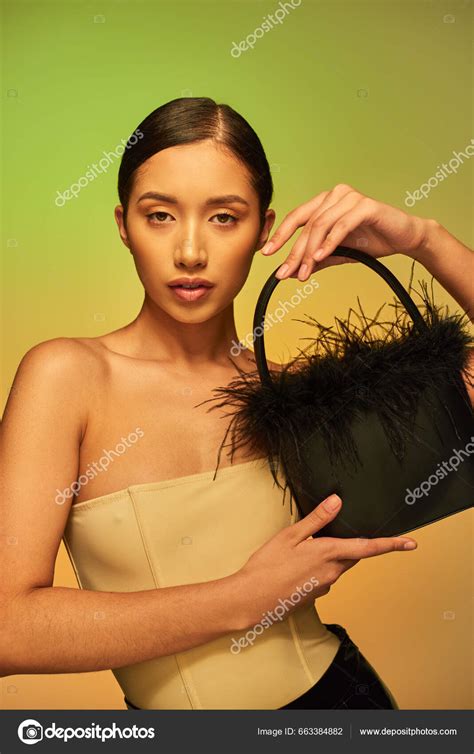 Fashion Forward Brunette Asian Woman Bare Shoulders Posing Feather