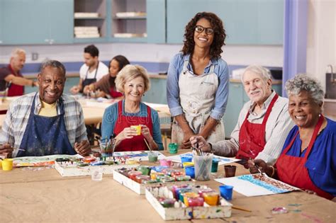 Group Of Retired Seniors Attending Art Class In Community Centre With Teacher Stock Image