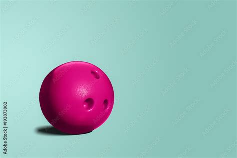 Pink bowling ball. A toy bowling ball of pink color on a blue ...