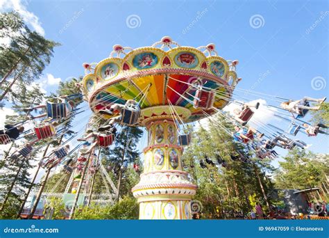 Colorful Chain Swing Carousel In Motion At Amusement Park On Blue Sky