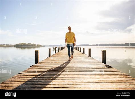 Mature Man Walking On Jetty At Lake Stock Photo Alamy