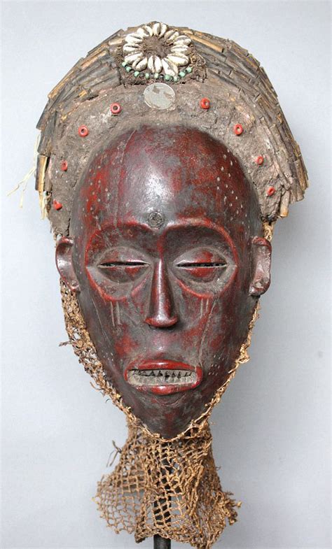 An African Mask Is Hanging On The Wall