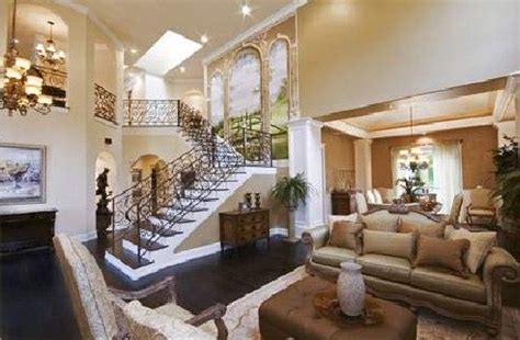 a living room filled with lots of furniture and a staircase leading up ...