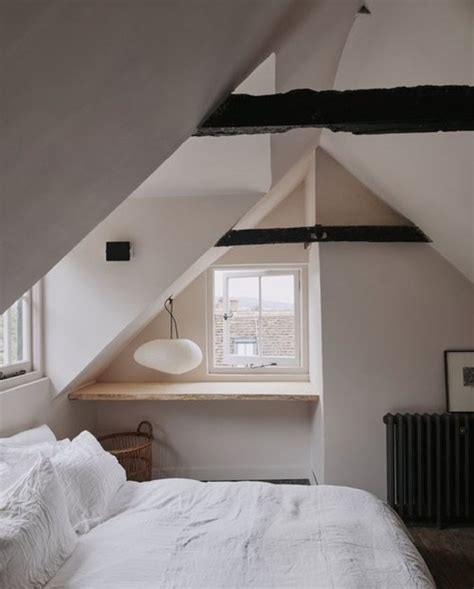 A Bed Sitting Under A Window In A Bedroom Next To A Radiator And Lamp