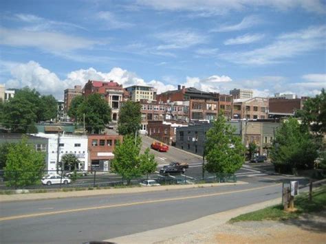 A City With Lots Of Tall Buildings And Cars Parked On The Side Of The Road