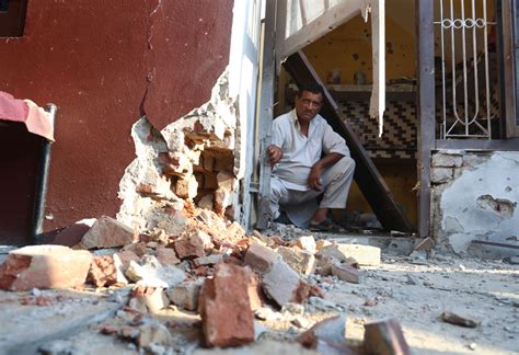 A border resident shows the portion of his building damaged in the ...