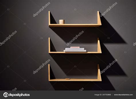 Luminous Interior With Dark Wall And Wooden Shelves Stock Photo