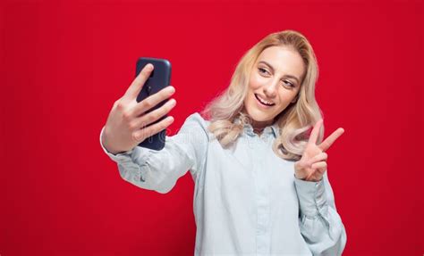 Trendy Girl Holding In Hands Smartphone And Making Selfie While Showing