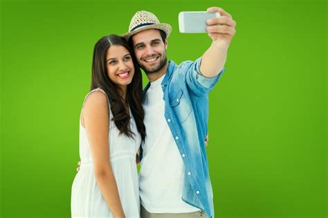 Feliz pareja hipster tomando un selfie contra viñeta verde Foto Premium