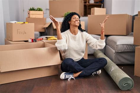 African American Woman Sitting On Floor With Winner Expression At New