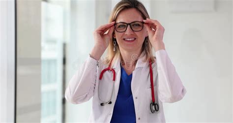 Female Doctor Puts On Glasses And Looks At Camera Stock Video Video