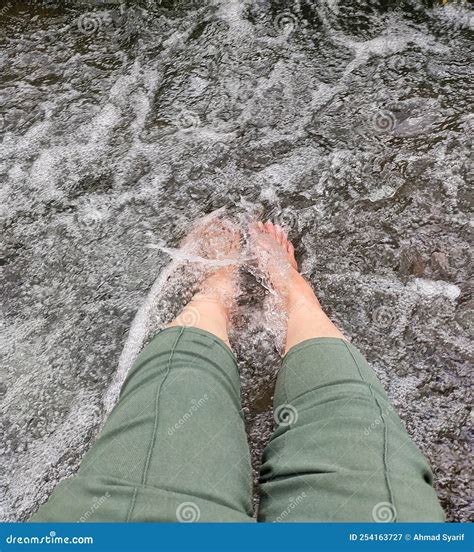 Play In The Clear River Flow By Inserting Both Feet In The River Flow