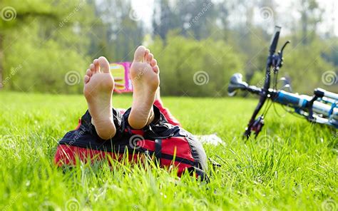 Le Cycliste Aux Pieds Nus Sur Une Halte Lit Se Situer Dans Lherbe