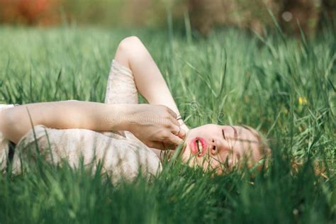 Outdoor Portrait Of Beautiful Blonde Girl Lying On Green Grass Stock Image Image Of