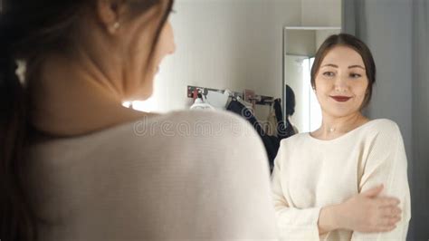 Fashionable Girl Looking In The Mirror In Fitting Room Stock Footage