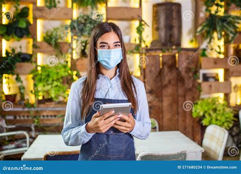 Happy Female Waitress Using Digital Tablet While Wearing Protective