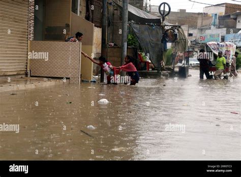 Karachi Aug People Wade Through Floodwater