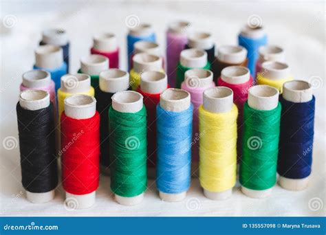 Group of Colored Thread Spools on White Cotton Cloth Stock Photo ...